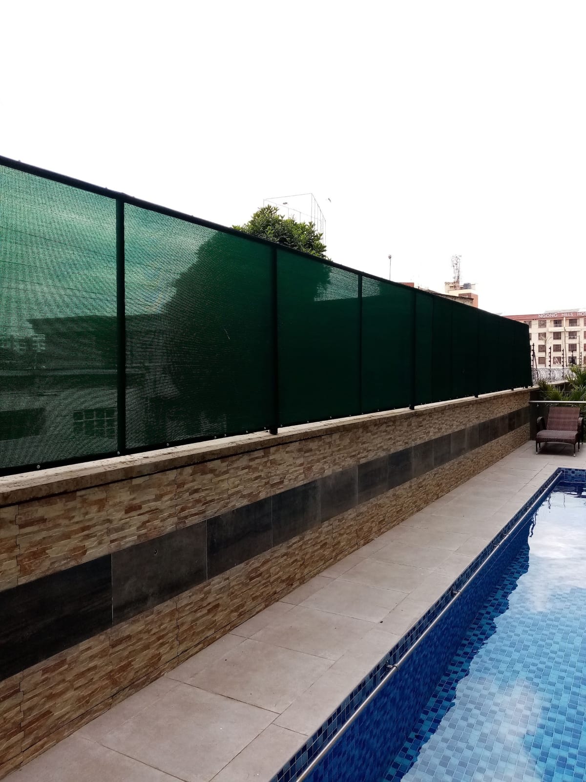 Green HDPE privacy shade net screen installed along a rooftop swimming pool deck in Nyali, Mombasa